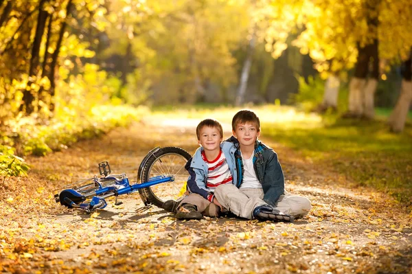 Zwei Jungen sitzen mit einem Fahrrad in einer Gasse — Stockfoto