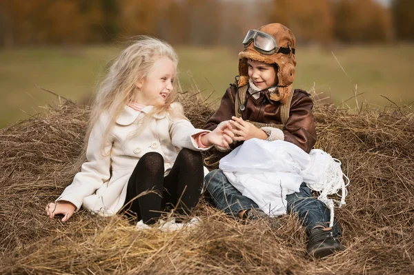 Мальчик и девочка на стоге сена — стоковое фото