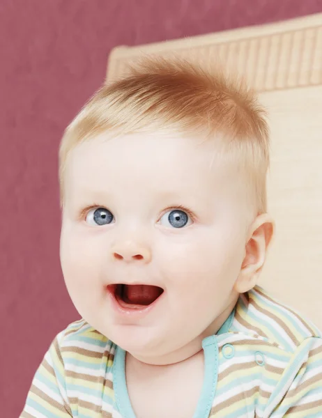 Lachende kleine jongen op een bed — Stockfoto