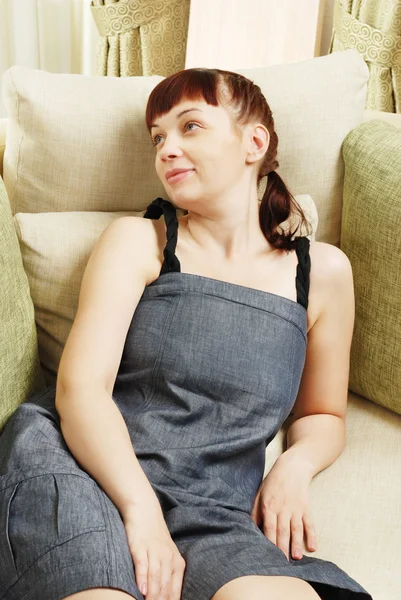 Das junge Mädchen ruht sich auf einem Sofa aus — Stockfoto