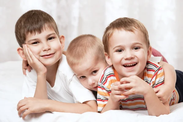 Три мальчика лежат на кровати — стоковое фото