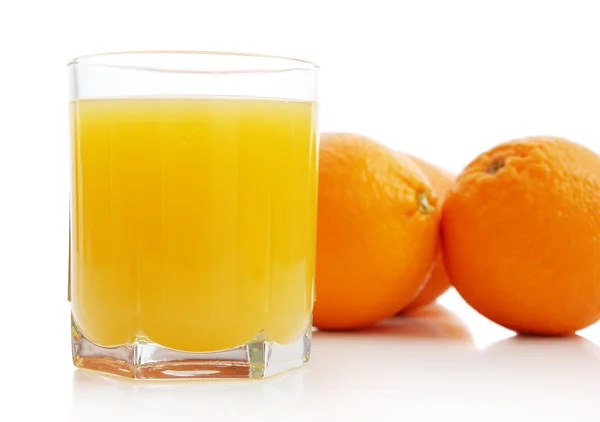 Orange juice and oranges — Stock Photo, Image