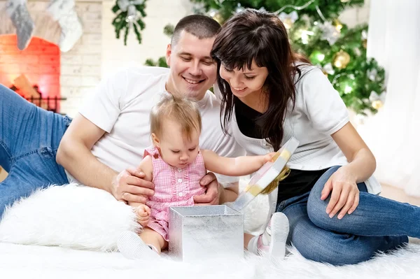 Young family at the Christmas tree — Stock Photo, Image
