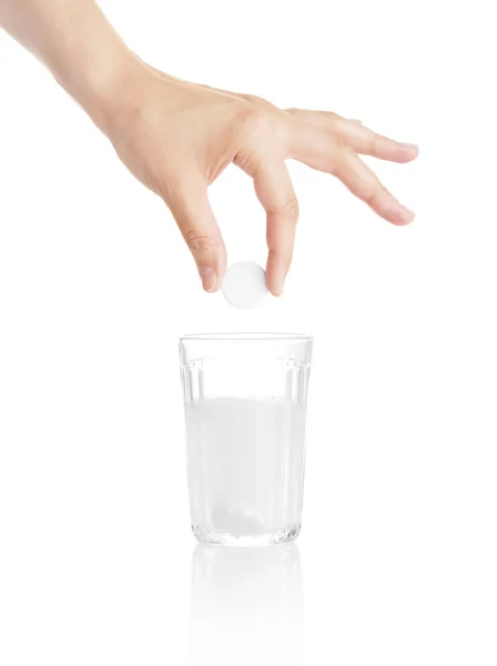 Tafel van kalmerend middel in een hand boven een glas — Stockfoto