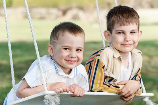 Two happy boys on a swing — Stock Photo, Image