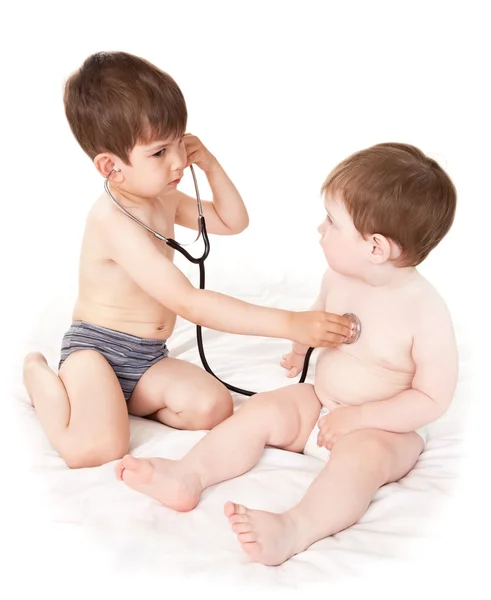 One boy listens to other boy a stethoscope Stock Picture