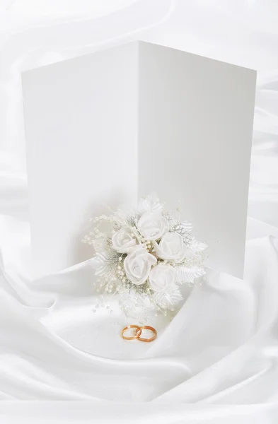 Bruiloft uitnodiging met ringen en een boeket — Stockfoto