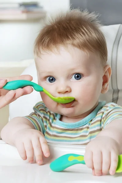 Mamãe alimenta o menino de uma colher — Fotografia de Stock