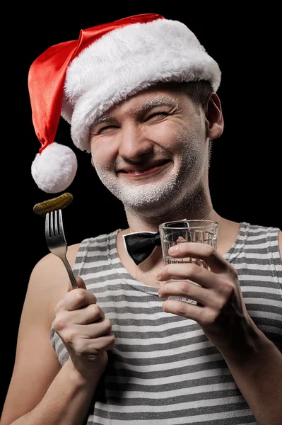 Санта-Клаус со стаканом водки и огурцом — стоковое фото