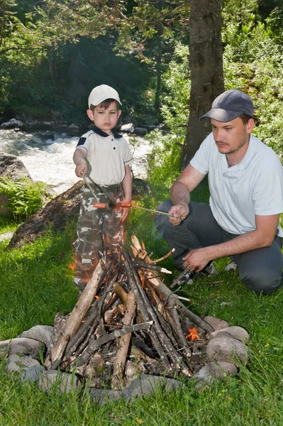 Daddy and the son fry sausages — Stock Photo, Image