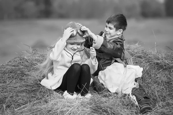 Мальчик и девочка на стоге сена — стоковое фото