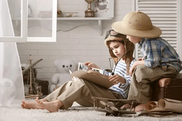 fiúk utazó tanulmányozása térképek és könyvek