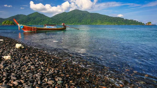 Barco de cola larga flotando en la hermosa playa de guijarros — Foto de Stock