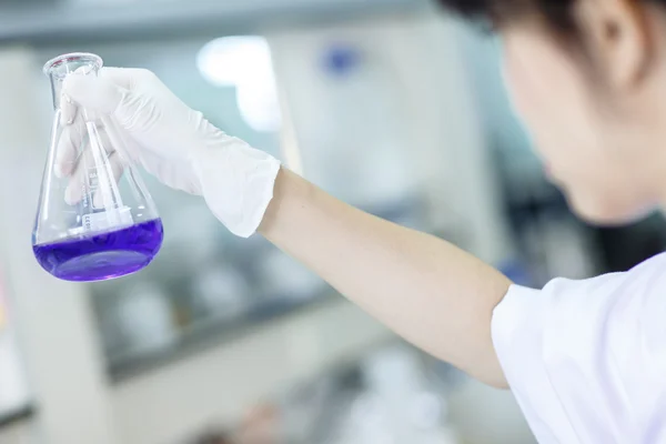 Scientist examining chemical in beaker — Stock Photo, Image