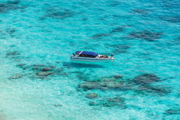 Aerial view of the tropical island, clear blue sea and a boat at