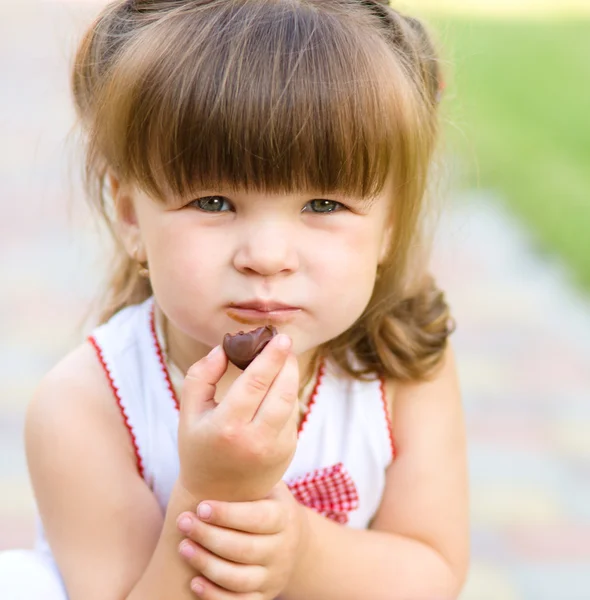 Niña está comiendo caramelos de chocolate —  Fotos de Stock