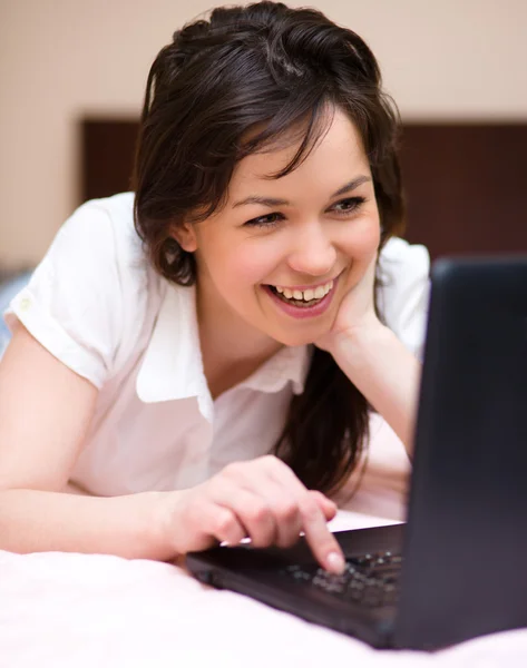 Giovane donna sta giocando sul computer portatile — Foto Stock