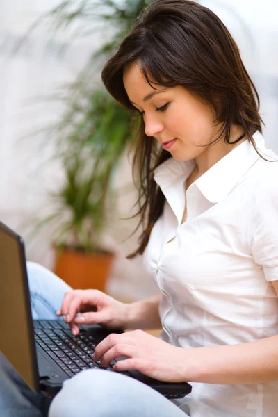Giovane donna sta giocando sul computer portatile — Foto Stock