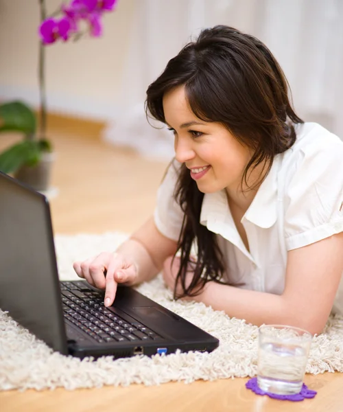 Jeune femme joue sur ordinateur portable — Photo