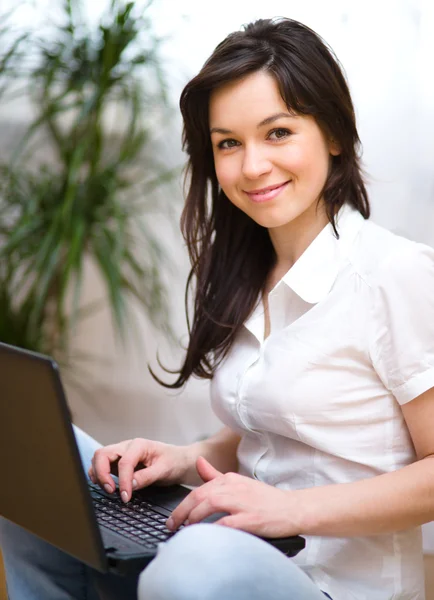 Giovane donna sta giocando sul computer portatile — Foto Stock