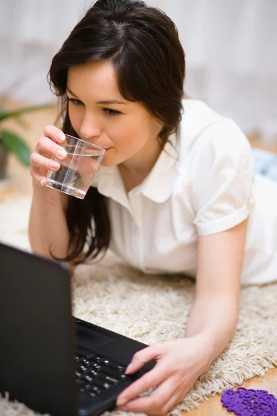 Jonge vrouw speelt op laptop — Stockfoto