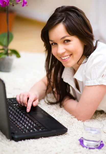 Giovane donna sta giocando sul computer portatile — Foto Stock