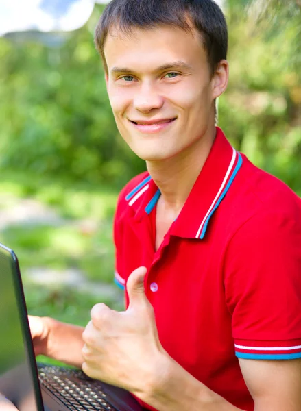 Young man is playing on laptop — Stock Photo, Image