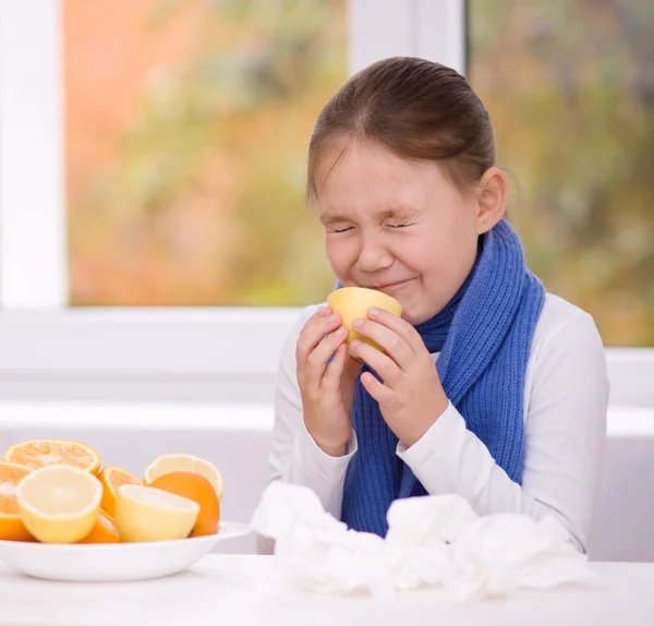 Lány megpróbál egy szelet narancs íz — Stock Fotó