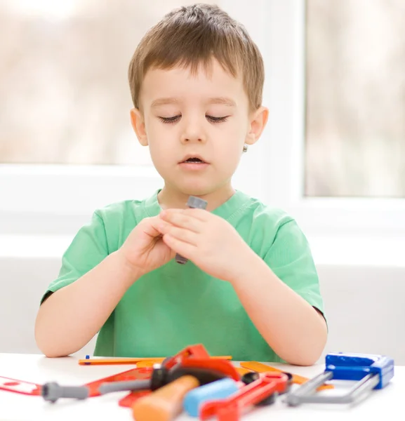 Boy is playing with tools — Stock Photo, Image