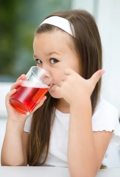 Den lille jenta drikker kirsebærjuice. – stockfoto