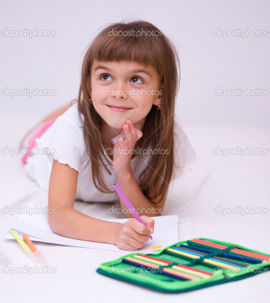 Bambina ¨ il disegno con matite colorate mentre posa sul pavimento — Foto di julaszka