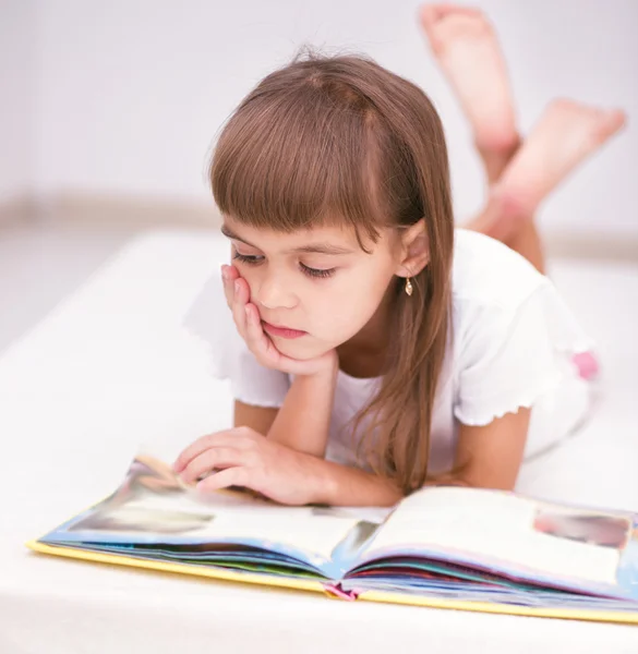 Menina está lendo um livro — Fotografia de Stock