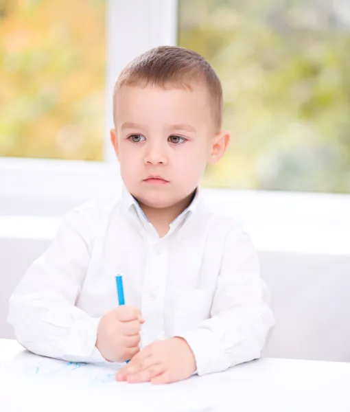 Menino está desenhando em papel branco — Fotografia de Stock