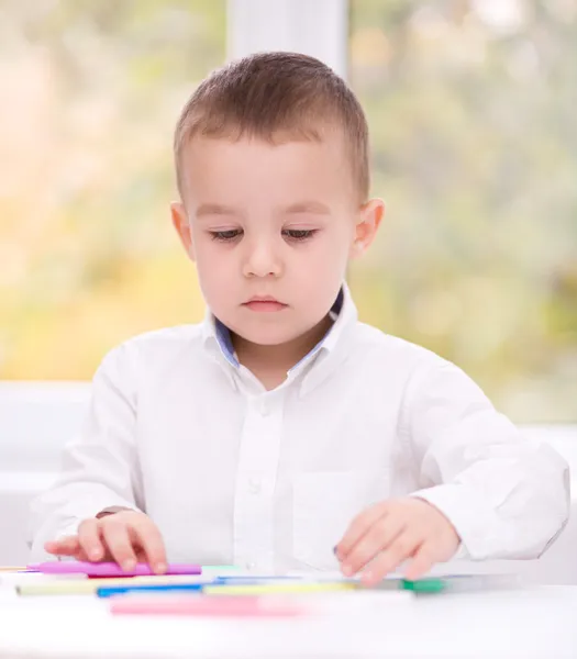 Menino está desenhando em papel branco — Fotografia de Stock