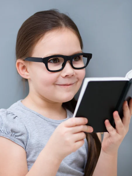 Klein meisje is het lezen van een boek — Stockfoto