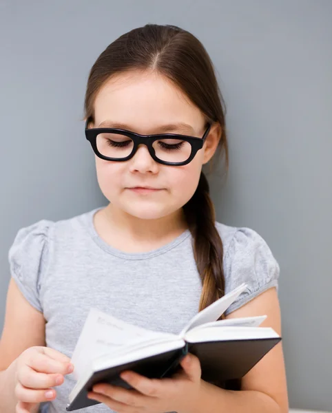 Klein meisje is het lezen van een boek — Stockfoto