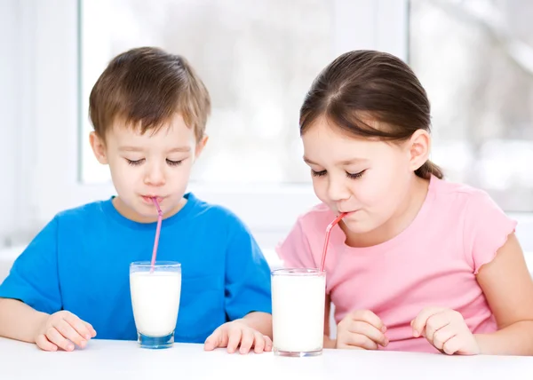 女孩和男孩喝美味新鲜的牛奶 — 图库照片