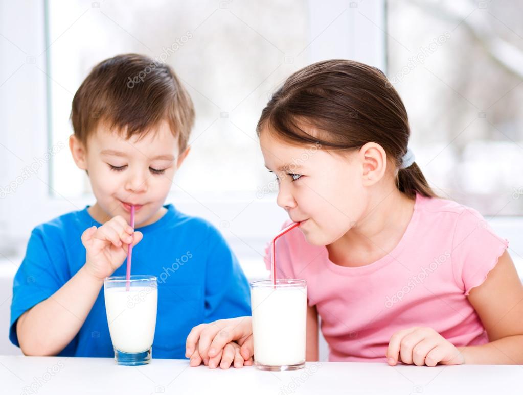 Girl and boy drink tasty fresh milk