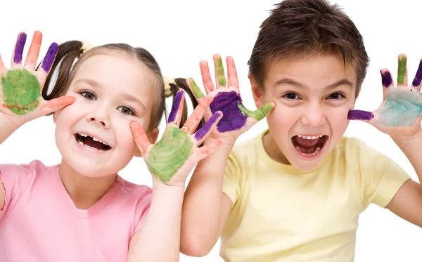 Süße Jungen und Mädchen spielen mit Farben — Stockfoto