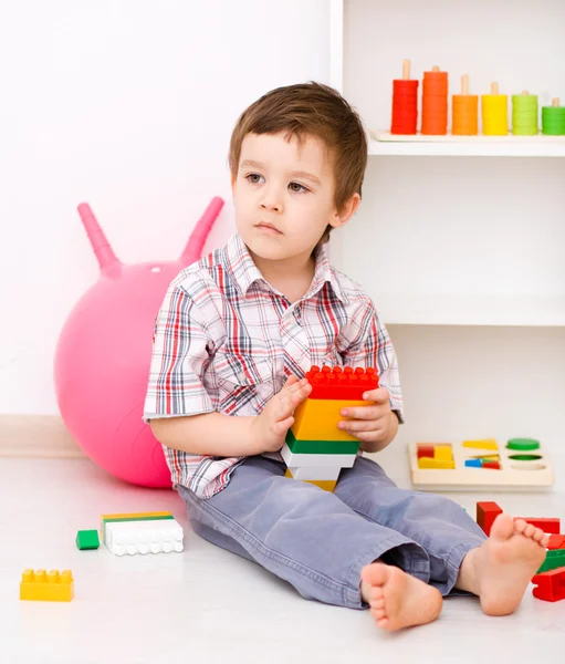 Chico está jugando con bloques de construcción — Foto de Stock