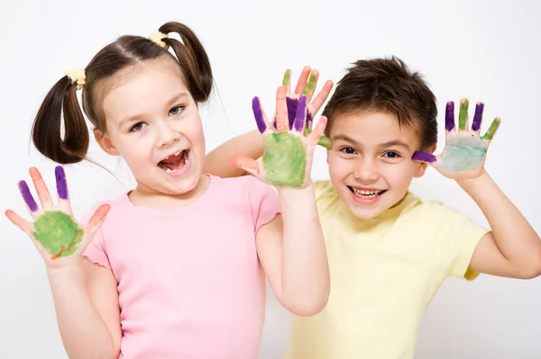 Süße Jungen und Mädchen spielen mit Farben — Stockfoto