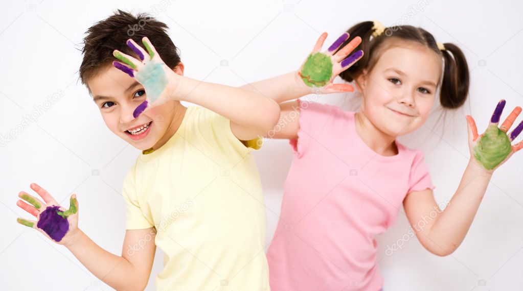 Cute boy and girl playing with paints
