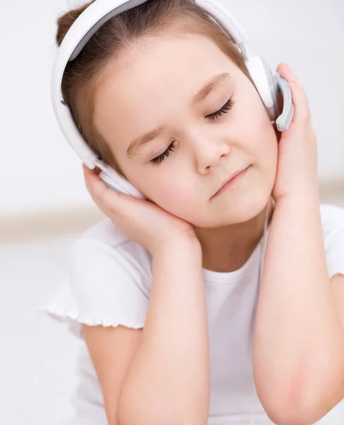 Niña está disfrutando de la música usando auriculares — Foto de Stock