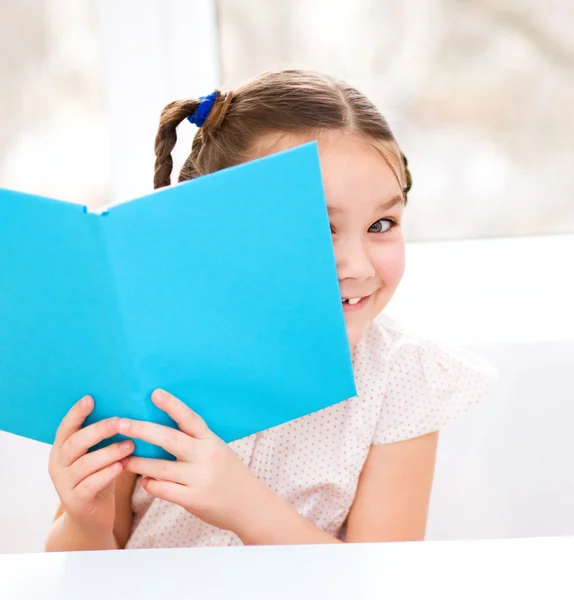 Klein meisje is het lezen van een boek — Stockfoto