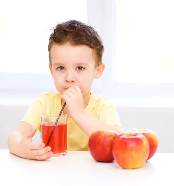 Petit garçon avec un verre de jus de pomme — Photo