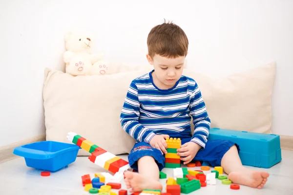 Boy is playing with building blocks — Stock Photo, Image