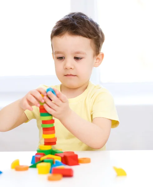 Chico está jugando con bloques de construcción — Foto de Stock