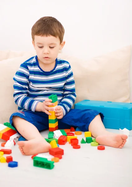 Chico está jugando con bloques de construcción — Foto de Stock