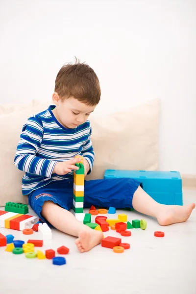 Chico está jugando con bloques de construcción —  Fotos de Stock