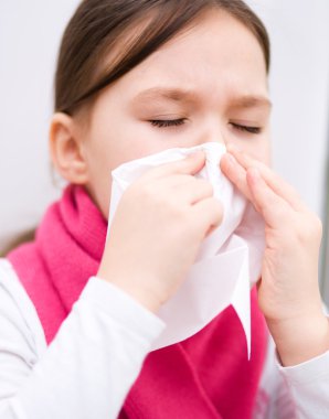 Kız burnunu siliyor.